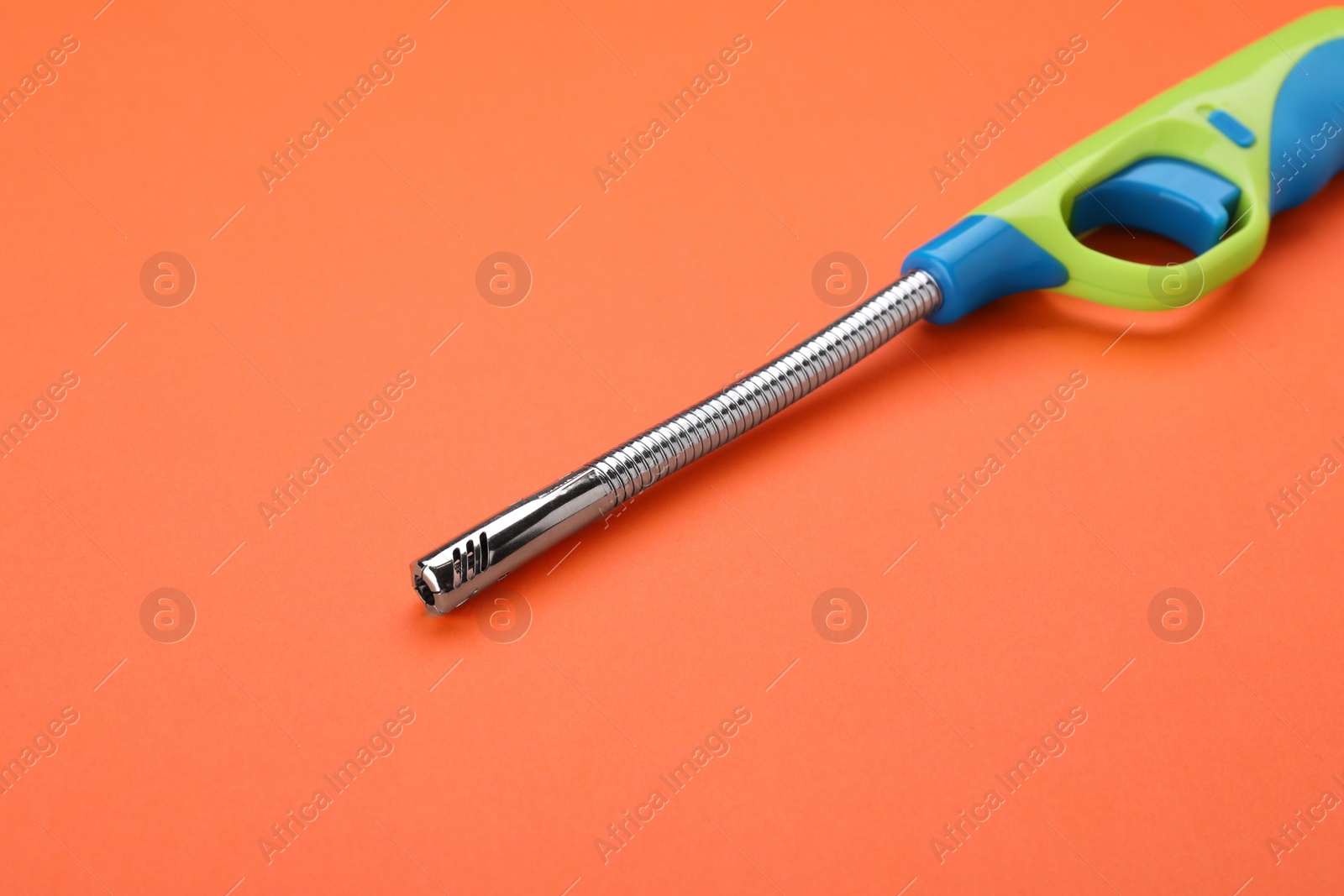 Photo of One gas lighter on orange background, closeup