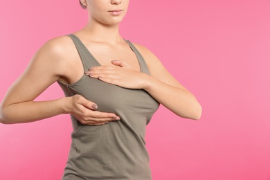 Photo of Woman checking her breast on color background, closeup. Space for text