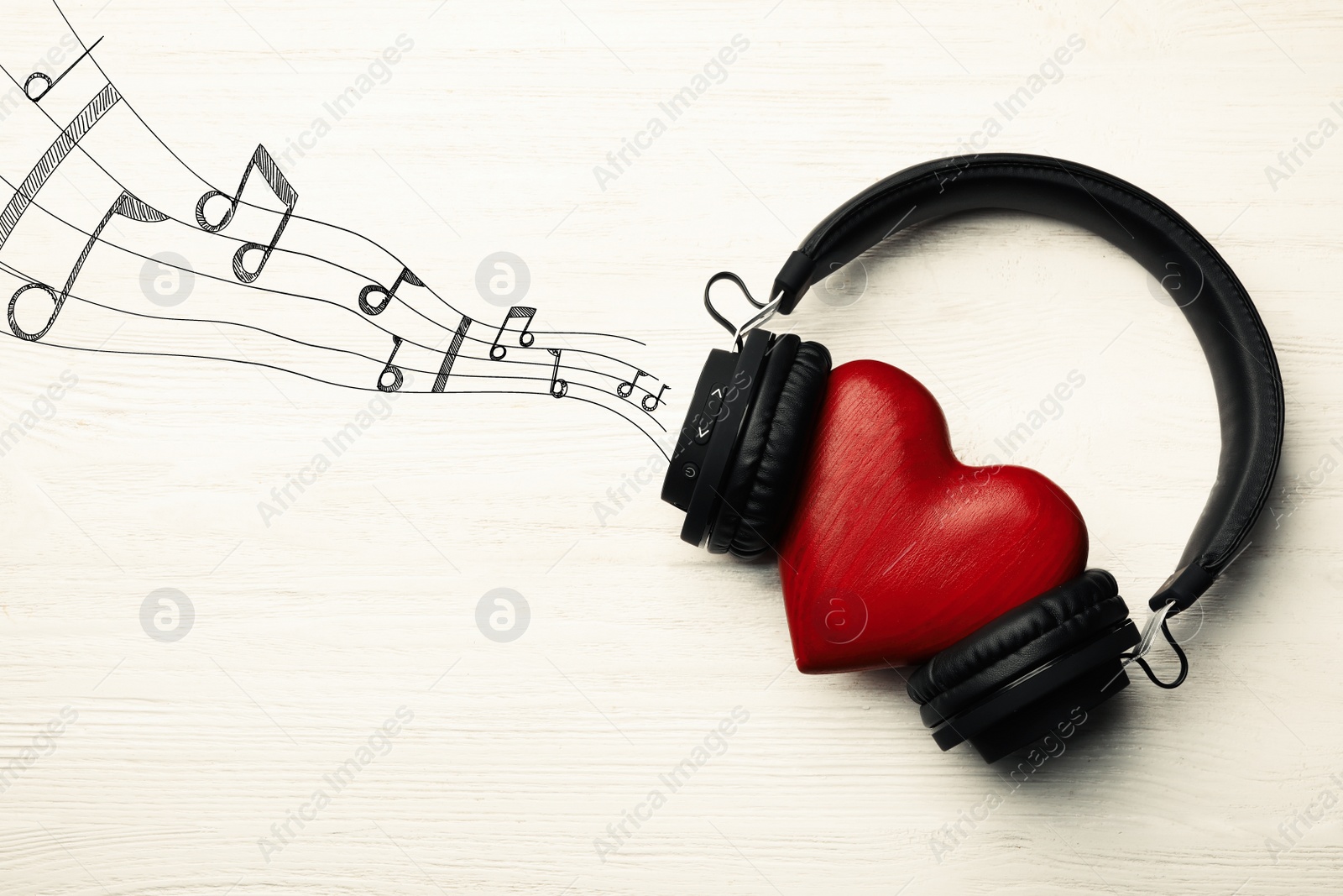 Image of Decorative heart with modern headphones on light background 