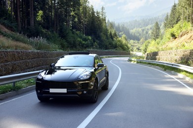 Photo of Picturesque view of asphalt road with modern black car outdoors