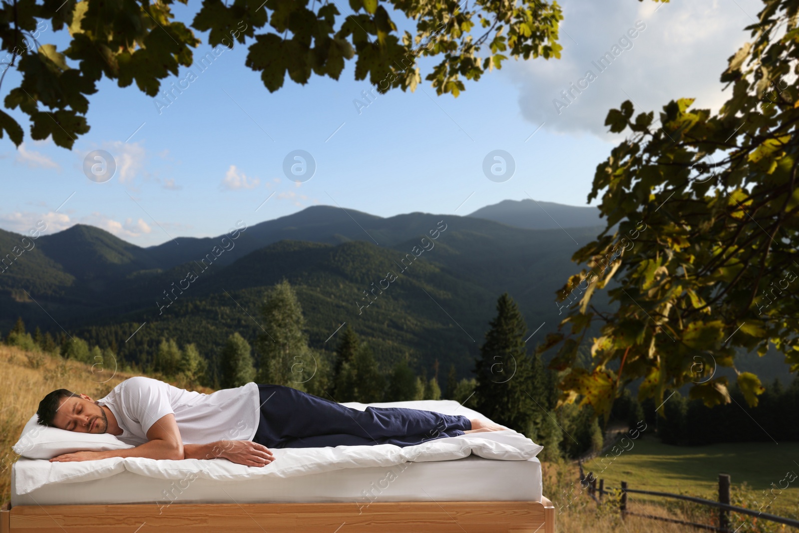 Image of Man sleeping on bed and beautiful view of mountain landscape on background. Sleep well - stay healthy