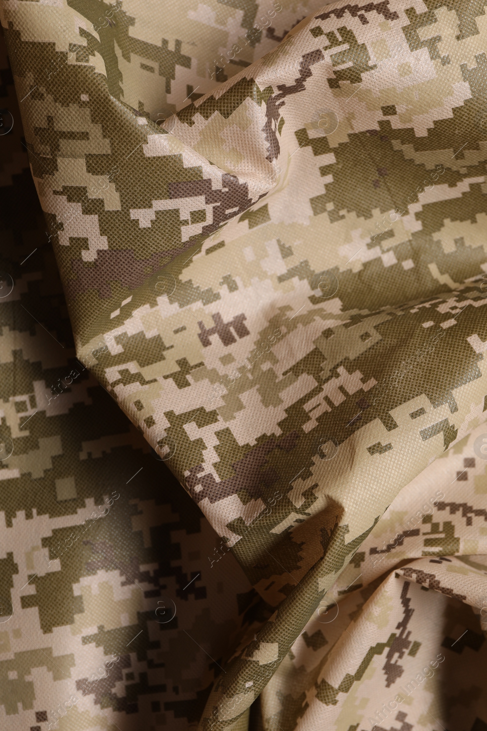 Photo of Texture of crumpled camouflage fabric as background, top view