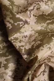 Texture of crumpled camouflage fabric as background, top view