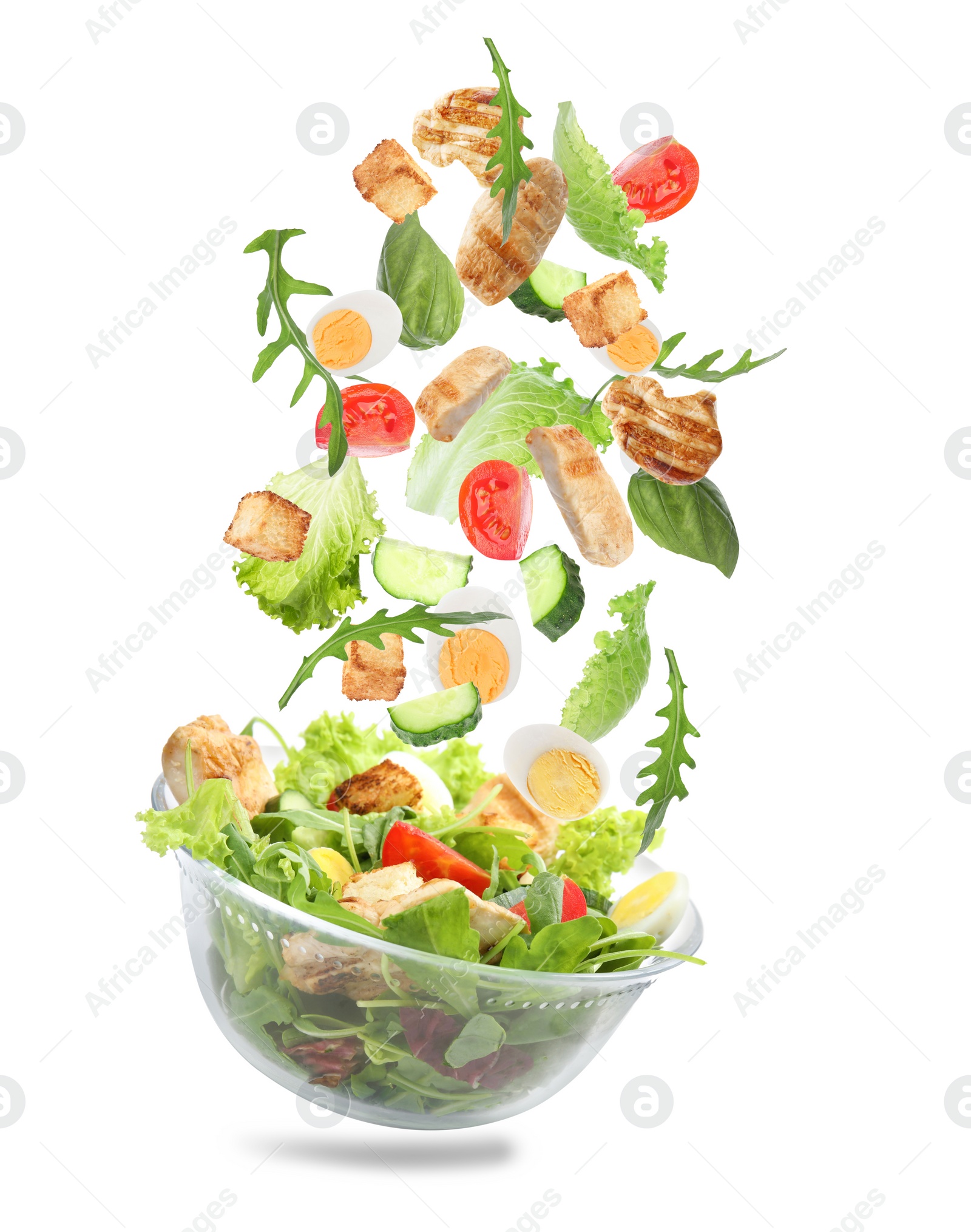 Image of Fresh ingredients for tasty salad falling into bowl on white background 