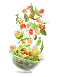 Image of Fresh ingredients for tasty salad falling into bowl on white background 