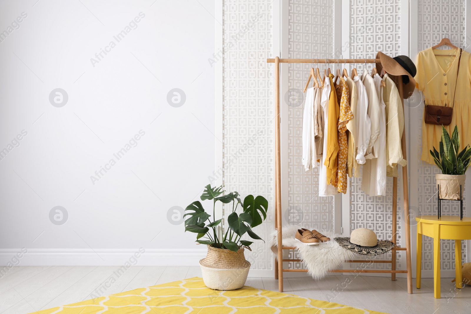 Photo of Rack with stylish women's clothes indoors. Interior design