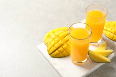 Fresh mango drink and cut fruits on table. Space for text