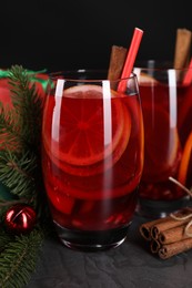 Photo of Delicious Sangria drink in glasses and Christmas decorations on dark textured table, closeup