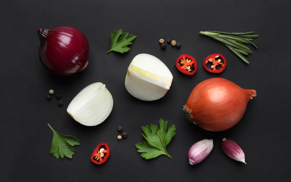 Flat lay composition with onion and spices on black background