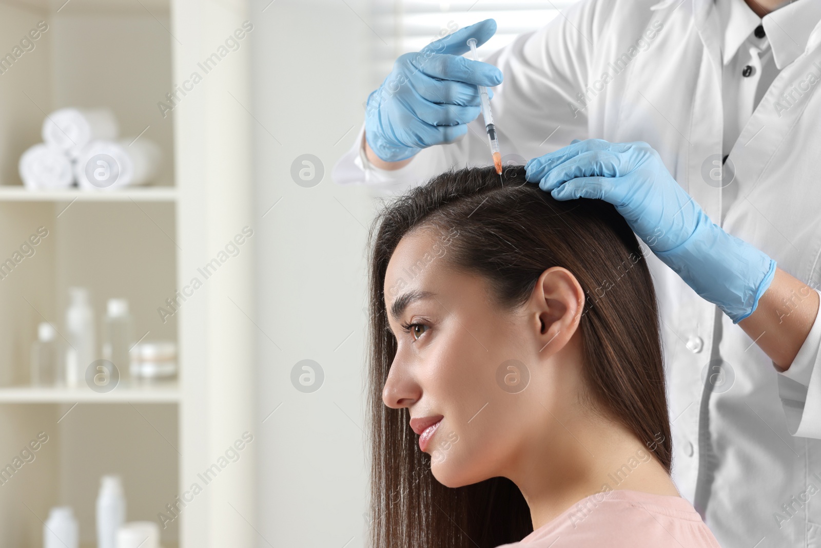 Photo of Trichologist giving injection to patient in clinic, closeup. Space for text