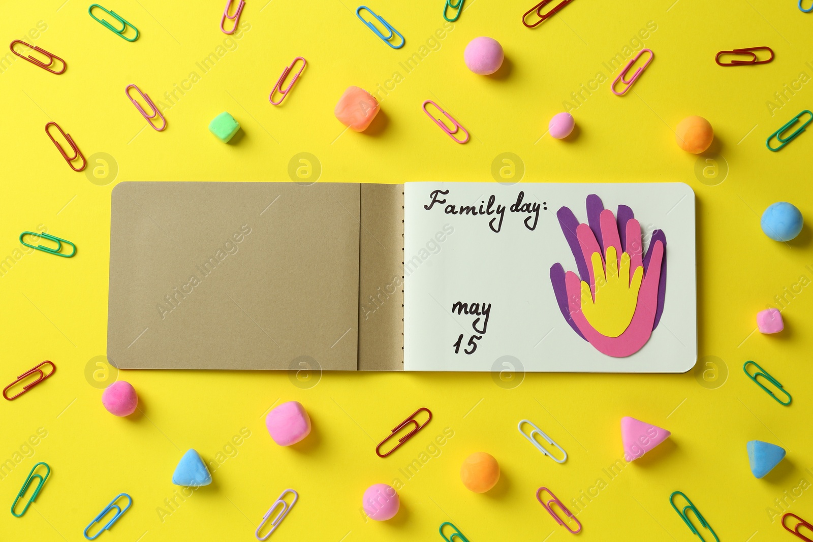 Photo of Happy Family Day. Flat lay composition with notebook on yellow background