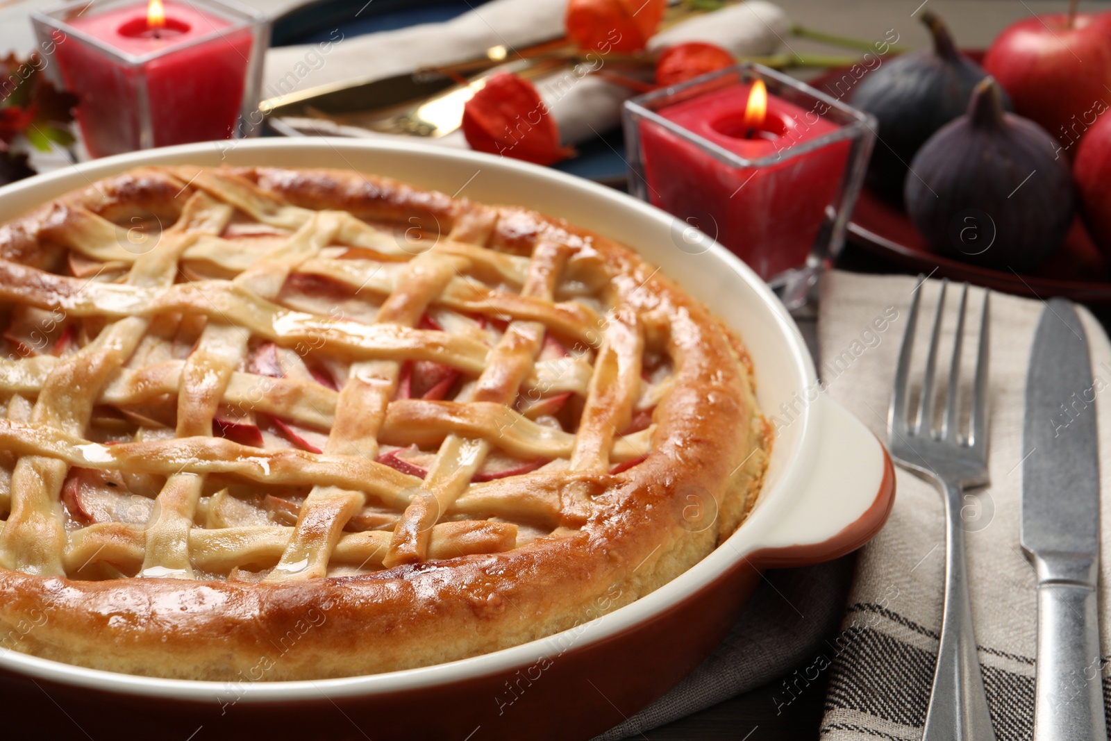 Photo of Delicious homemade apple pie and autumn decor on table, closeup. Thanksgiving Day celebration