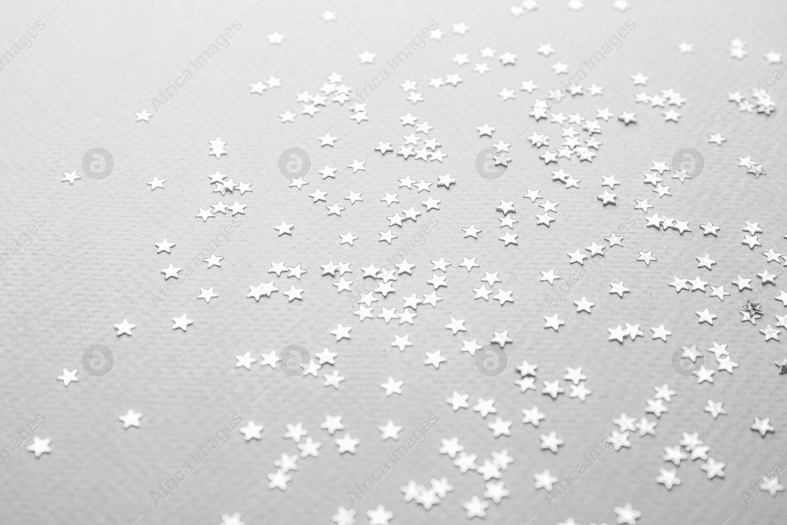 Photo of Confetti stars on grey background. Christmas celebration