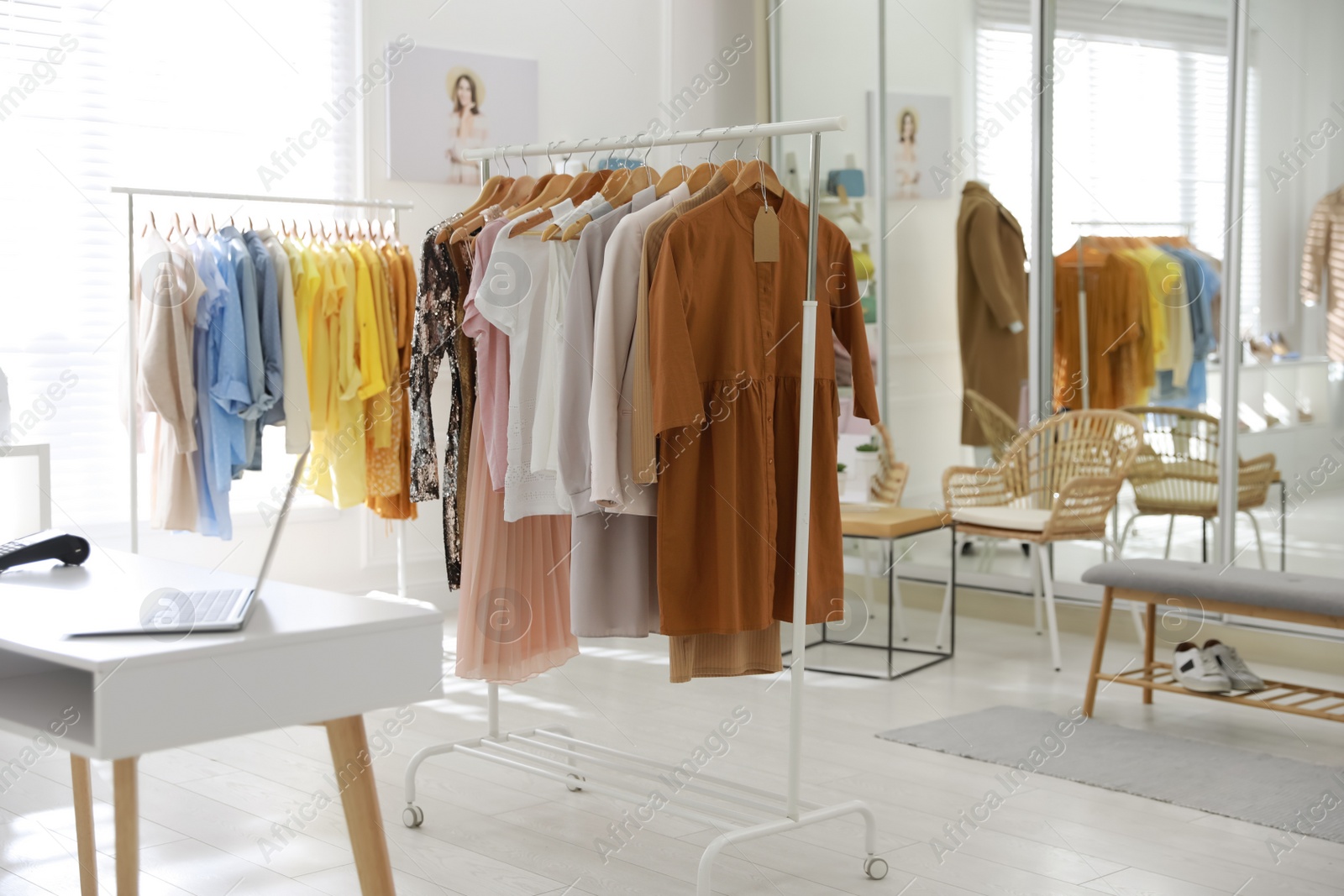 Photo of Stylish women's clothes on rack in modern boutique