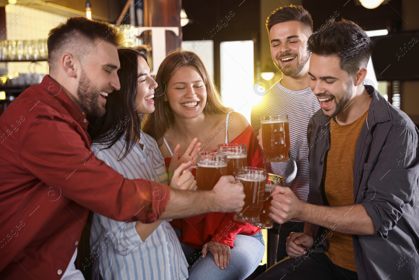 Photo of Group of friends celebrating victory of favorite football team in sport bar