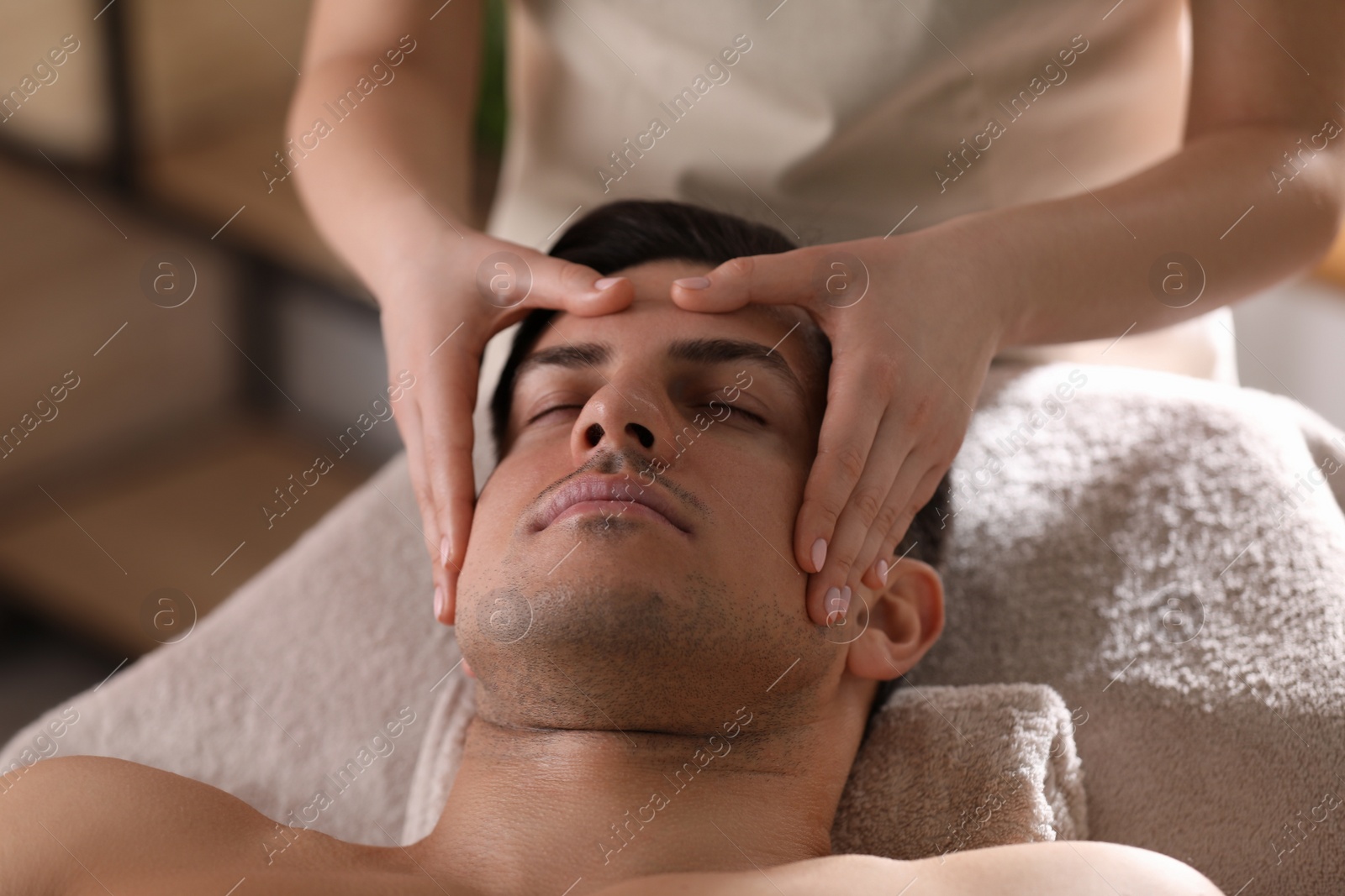 Photo of Man receiving facial massage in beauty salon