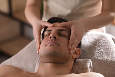 Man receiving facial massage in beauty salon