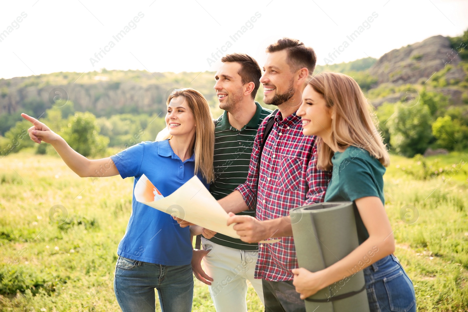 Photo of Young people exploring map in wilderness. Camping season