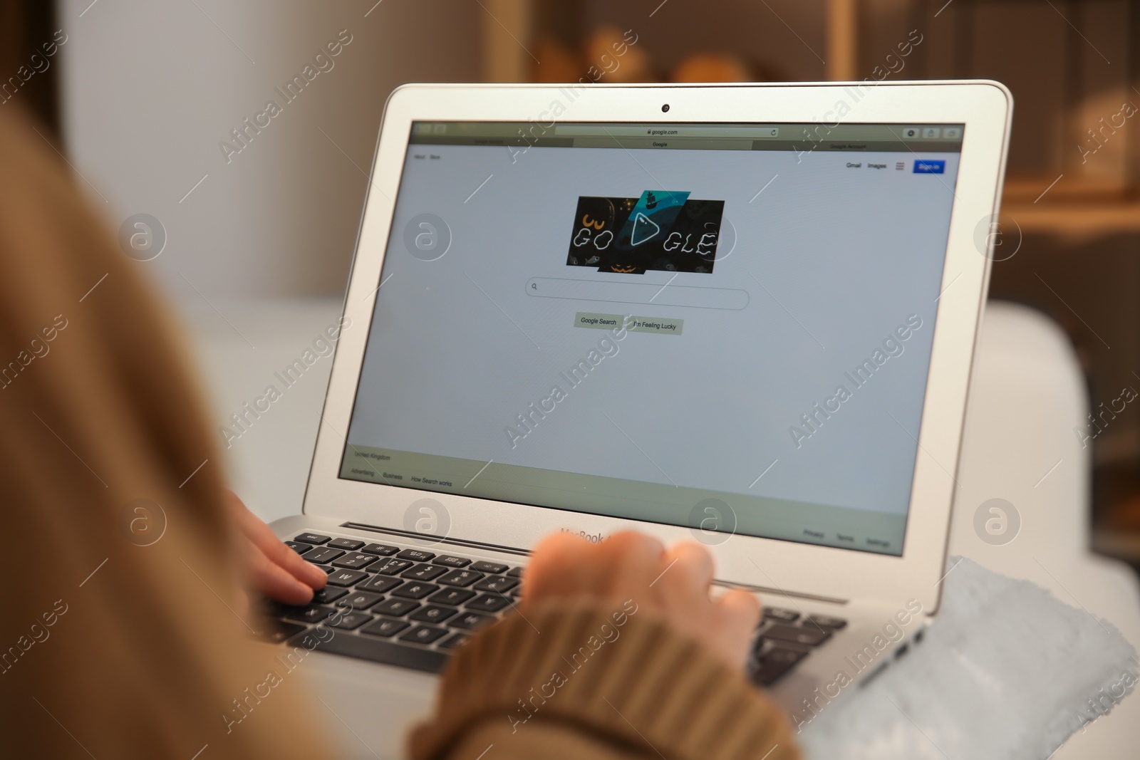 Photo of MYKOLAIV, UKRAINE - OCTOBER 31, 2020: Woman using Google search engine on MacBook Air laptop indoors, closeup