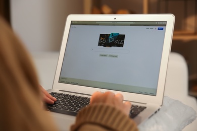 Photo of MYKOLAIV, UKRAINE - OCTOBER 31, 2020: Woman using Google search engine on MacBook Air laptop indoors, closeup