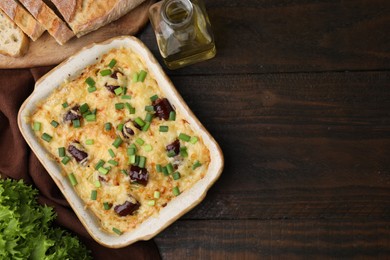 Photo of Tasty sausage casserole with green onions in baking dish on wooden table, flat lay. Space for text