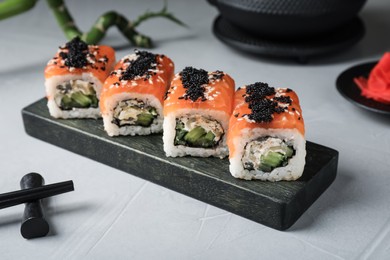 Photo of Delicious sushi rolls served on light grey table