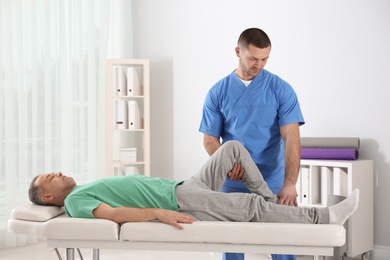 Photo of Doctor working with patient in hospital. Rehabilitation physiotherapy