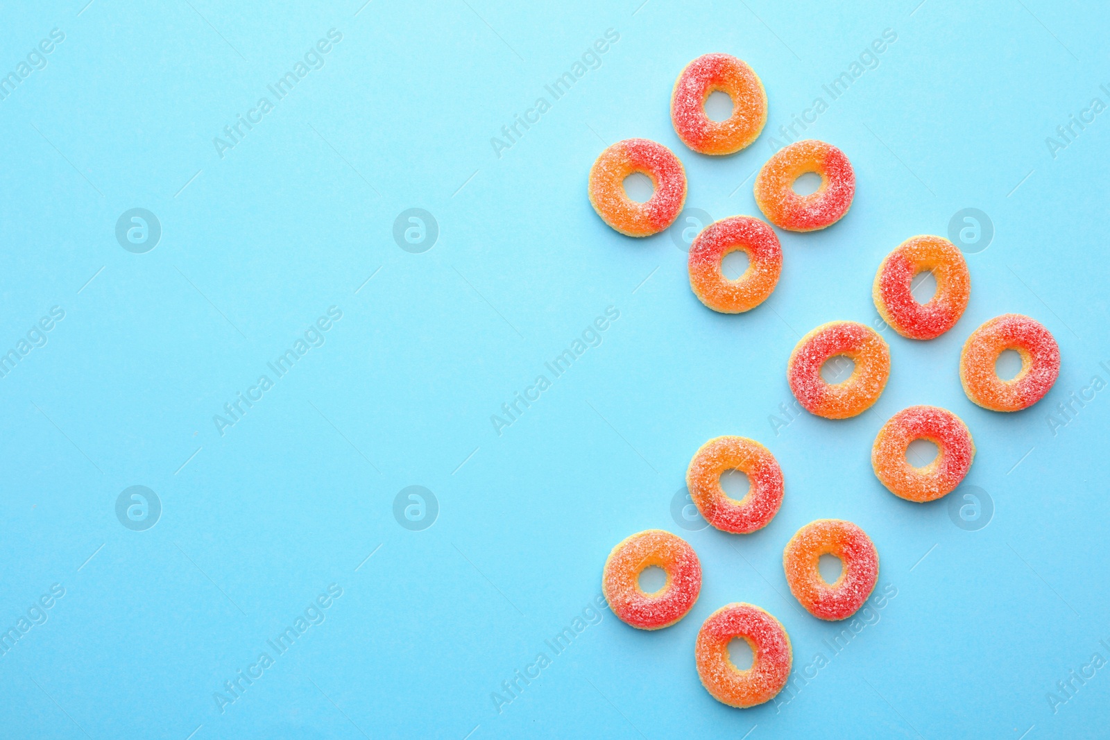 Photo of Flat lay composition with tasty jelly candies and space for text on color background