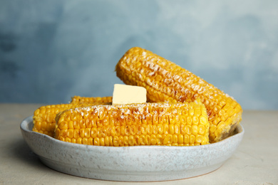 Photo of Delicious grilled corn with butter on table