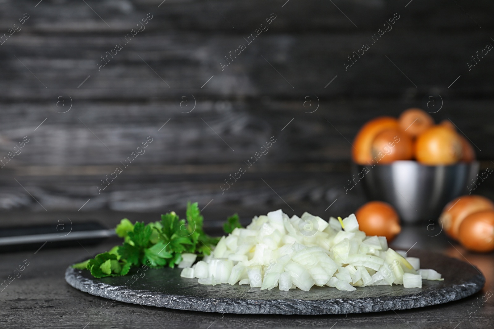 Photo of Slate plate with fresh chopped onion on table