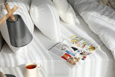 Magazine on bed with clean white linens indoors