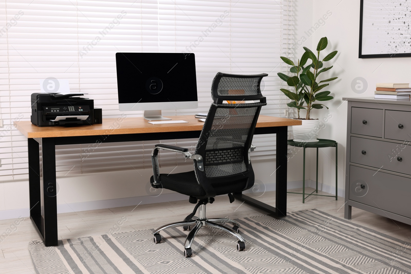 Photo of Stylish room interior with desk, modern printer and computer