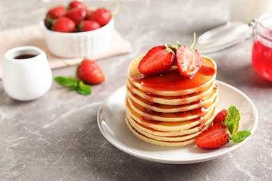 Photo of Plate with pancakes and berries on table