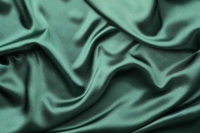 Photo of Crumpled green silk fabric as background, top view
