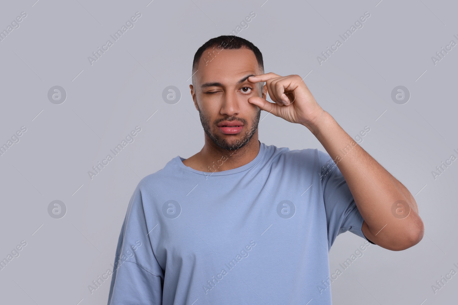 Photo of Tired man on light grey background. Insomnia problem
