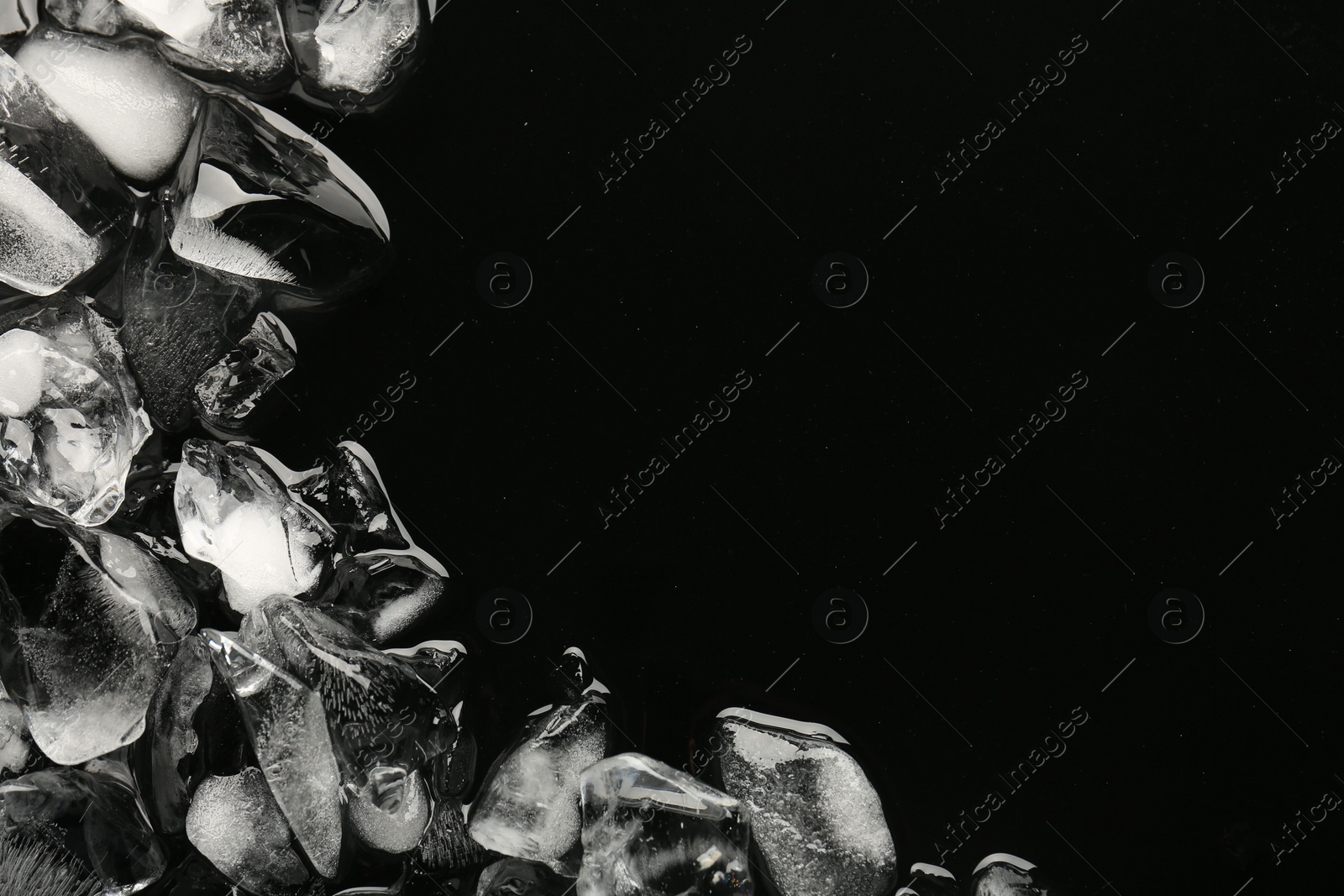 Photo of Pieces of crushed ice on black background