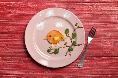 Flat lay composition with pancake in form of bird on wooden background. Creative breakfast ideas for kids