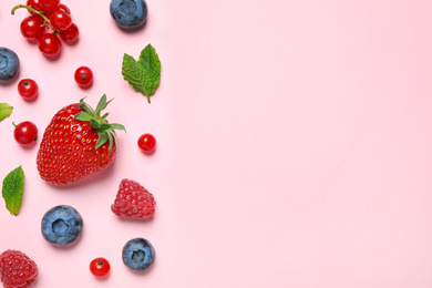 Photo of Mix of fresh berries on pink background, flat lay. Space for text