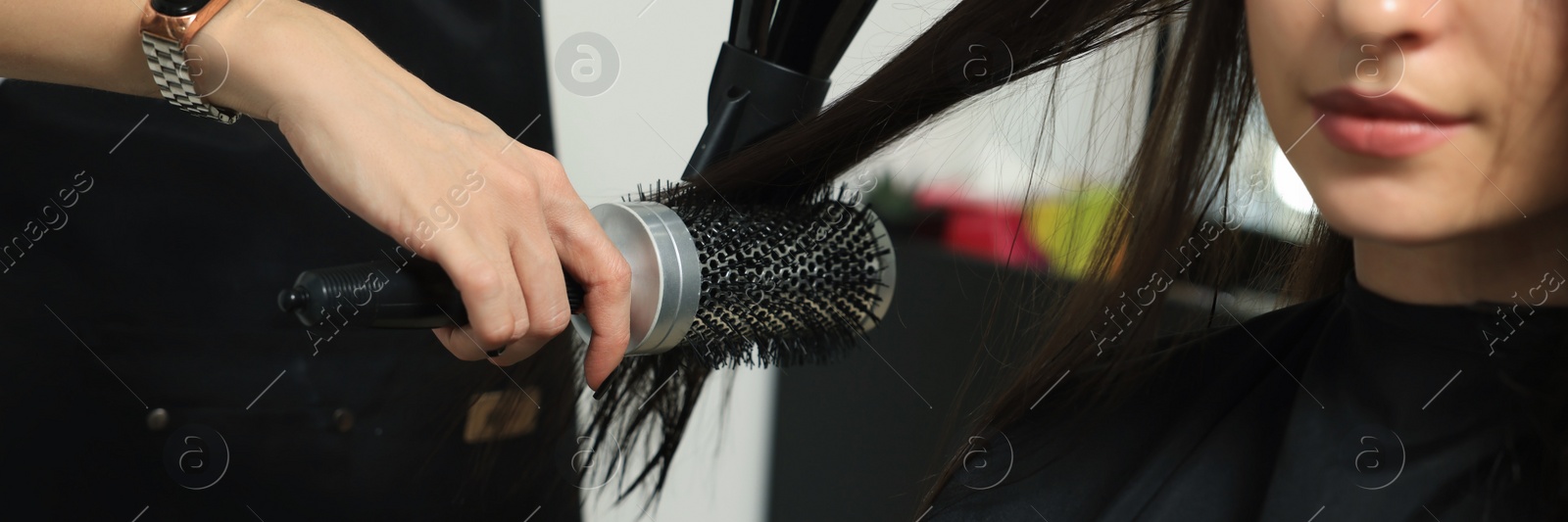 Image of Hairdresser drying woman's hair in beauty salon. Banner design