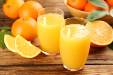 Orange juice and fresh fruits on wooden table