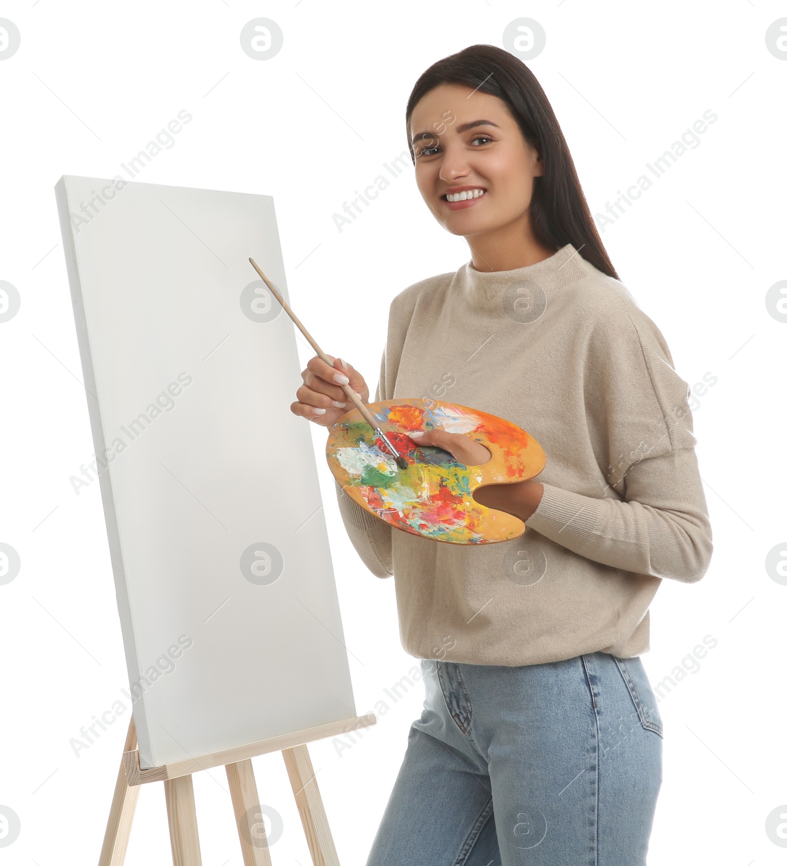 Photo of Young woman drawing on easel against white background