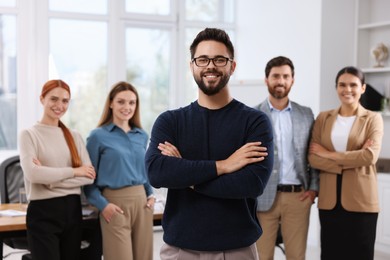 Portrait of happy businessman and his team in office