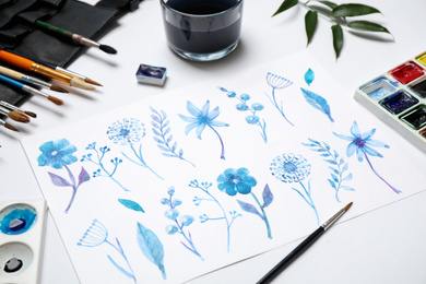 Photo of Composition with beautiful floral picture and watercolor paints on white background