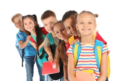 Photo of Group of little children with backpacks and school supplies on white background