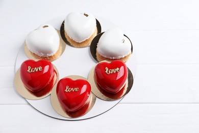 Photo of St. Valentine's Day. Delicious heart shaped cakes on white wooden table. Space for text