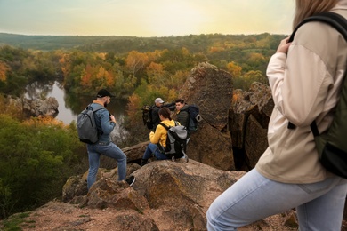 Group of hikers with backpacks climbing down mountain