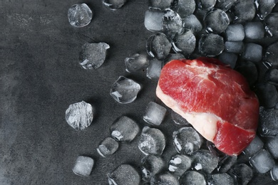 Photo of Flat lay composition with raw meat and ice cubes on dark background