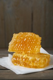 Photo of Natural honeycombs on wooden table, space for text