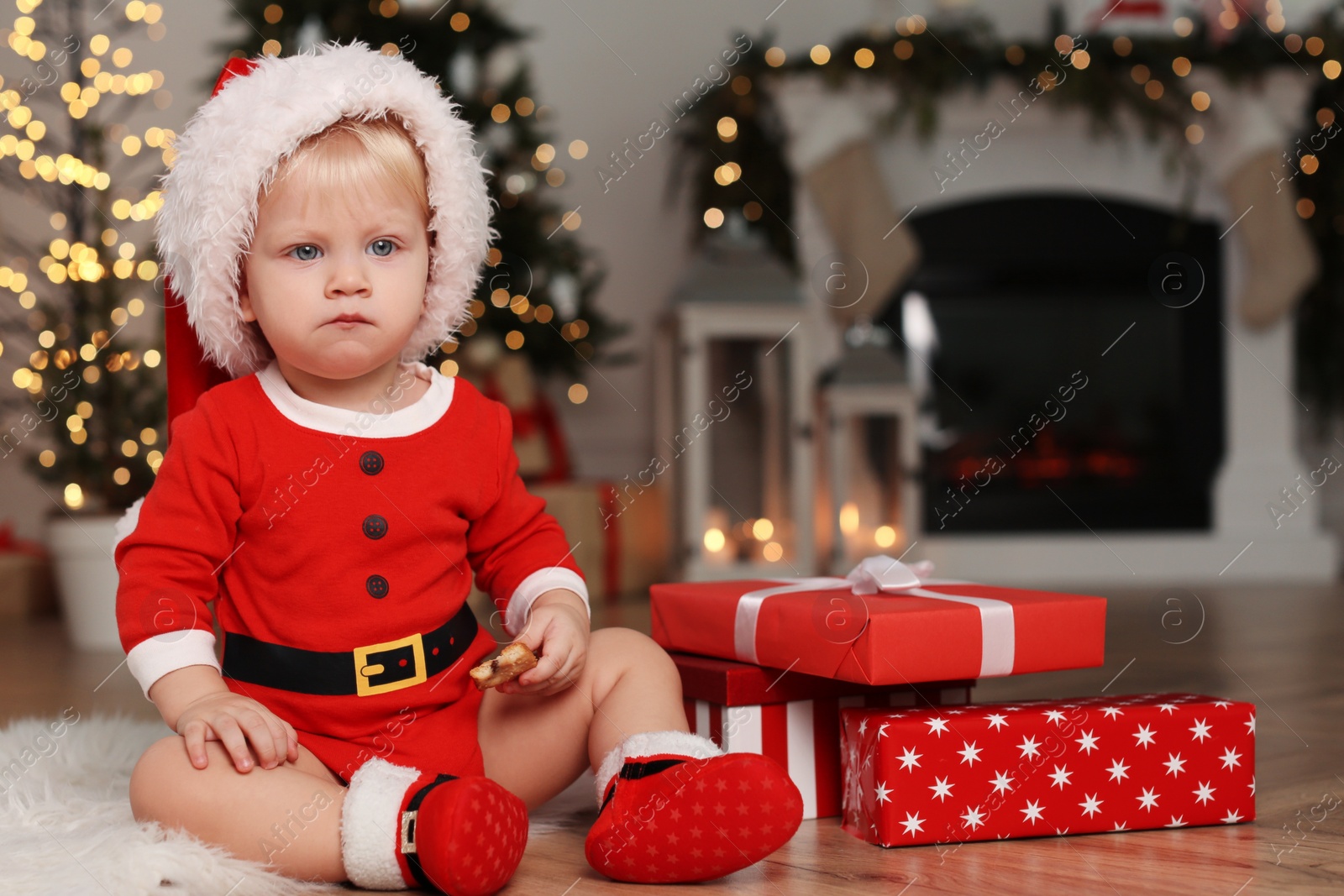 Photo of Baby in cute Christmas outfit with gifts at home