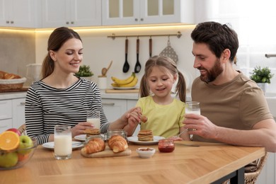 Happy family having breakfast at table in kitchen